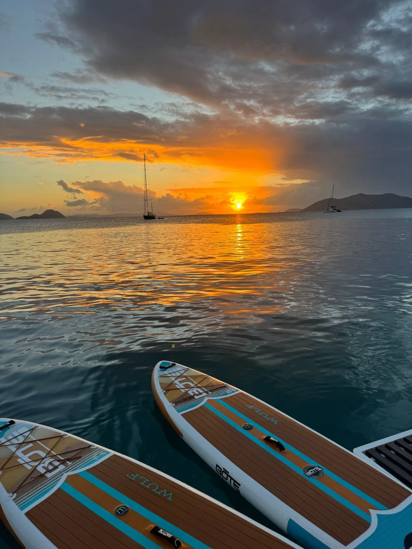 Paddleboards on glassy water at sunset