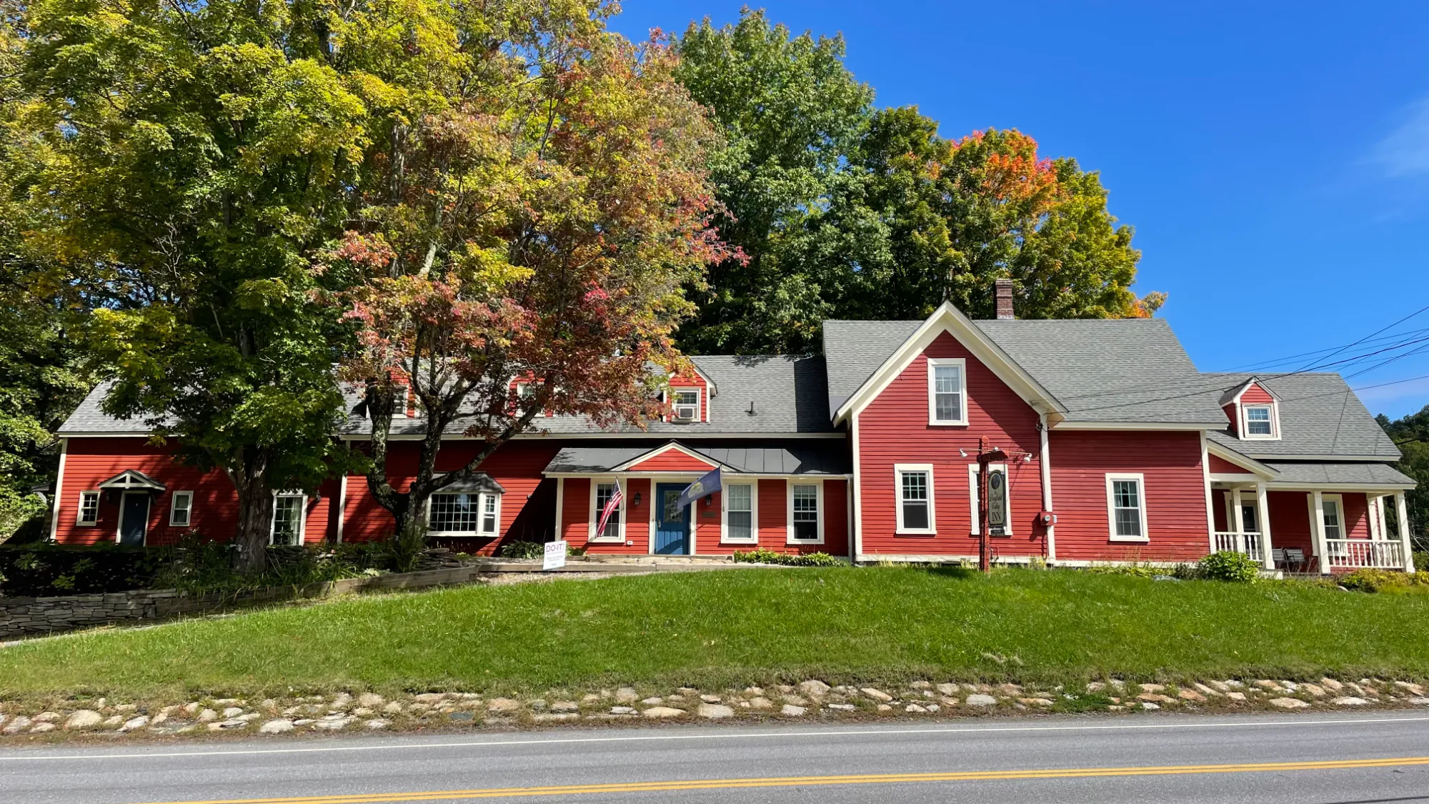 Deerfield Valley Inn — historic red farmhouse-style B&B near Mount Snow, Vermont, framed by autumn maples
